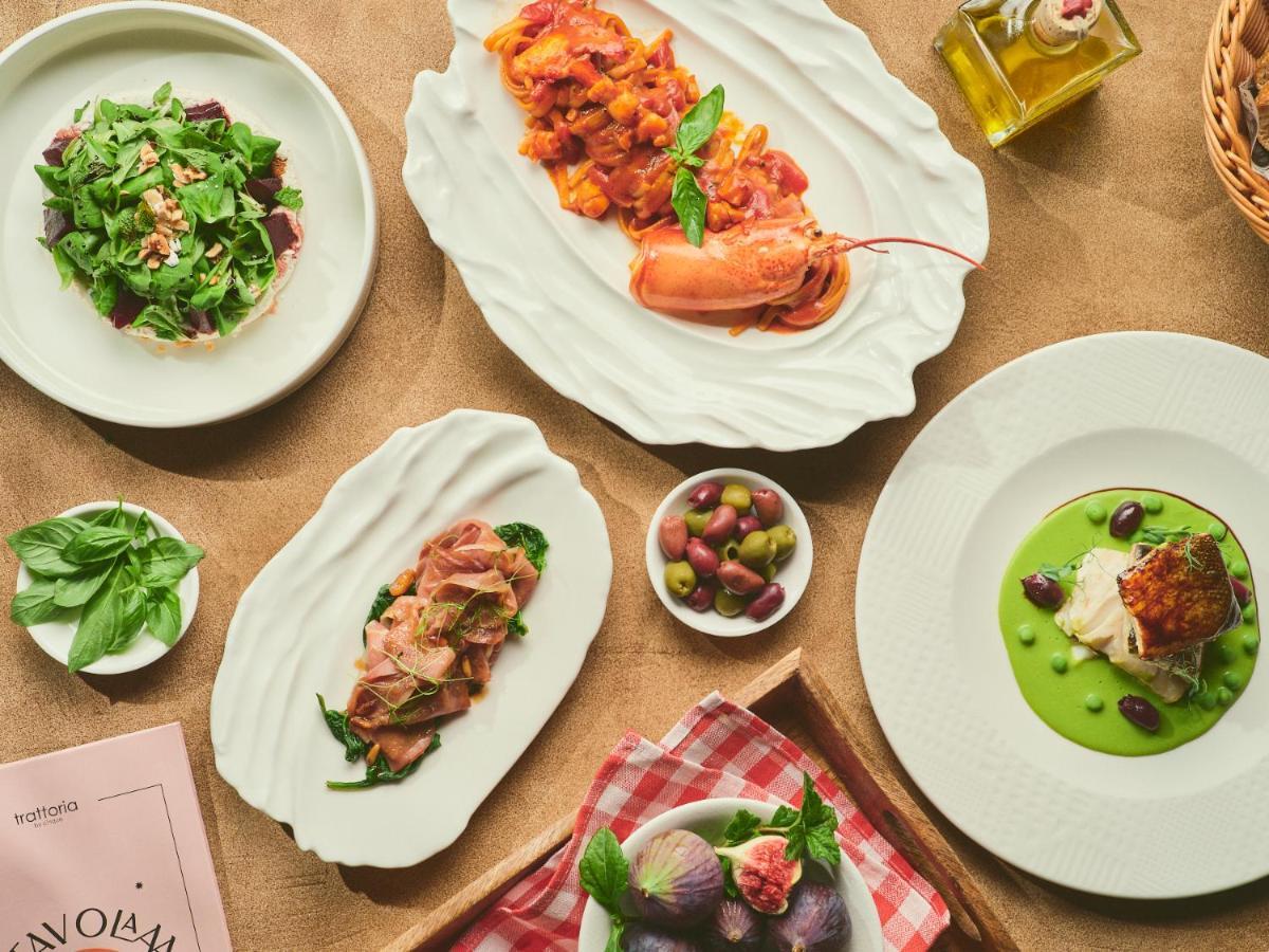 Five Jumeirah Village Dubai Esterno foto The photo displays an array of elegant dishes arranged on a table. Here's a description of what appears to be presented:

1. **Salad**: A fresh green salad served in a round bowl, featuring leafy greens and possibly other vegetables.
  
2. **Seafood 