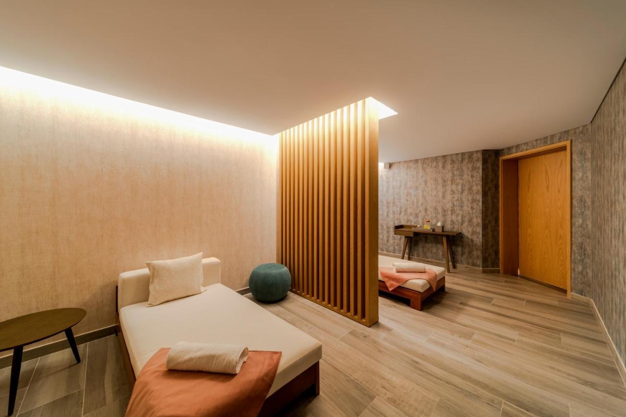 Five Jumeirah Village Dubai Esterno foto The photo depicts a calm and modern interior space, likely a relaxation or wellness area. It features a light-colored wood floor and soothing wall textures. 

On one side, there’s a daybed with soft cushions, accompanied by a small round table. A blu